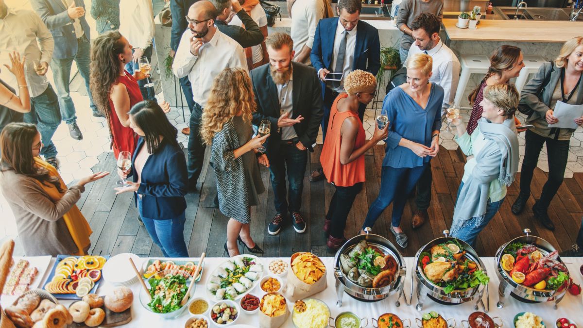 Gesellige Atmosphäre bei einem Event mit Buffet im Vordergrund.